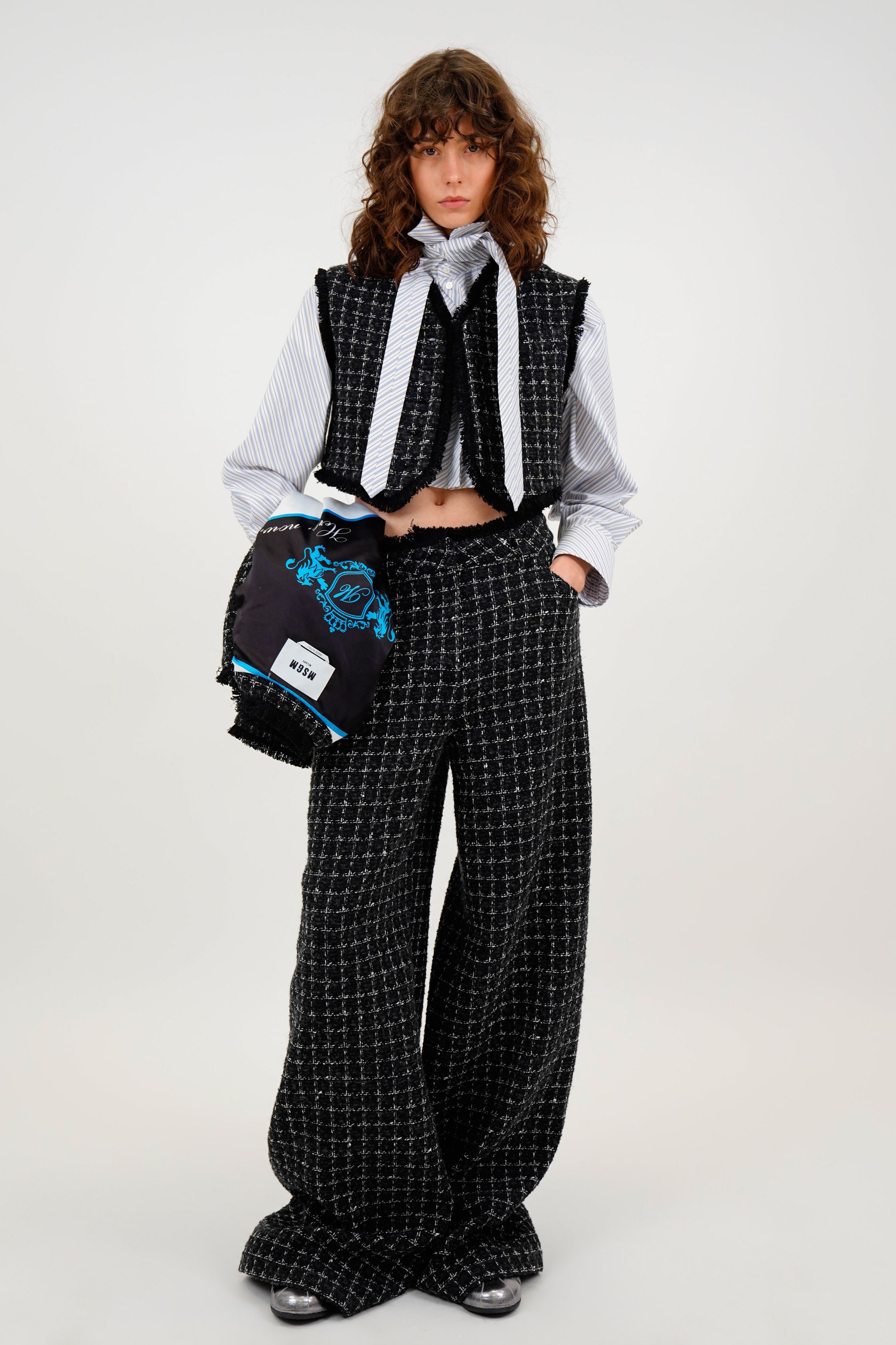 MSGM 2026秋冬以青年文化与学院风为切口，重新激活90年代街头记忆。宽腿彩色牛仔、菱格针织、短款上装与随性叠穿构建出不受性别限制的造型语言，紫色、亮蓝与黑白对比成为视觉焦点。系列在“玩味”与“结构”之间取得平衡，保留品牌标志性的青春躁动，同时注入更成熟的造型逻辑，呈现出Z世代走向理性阶段的风格转折-顽石频道趋势研究